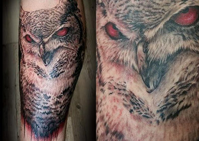 A tattoo of an owl with red eyes.