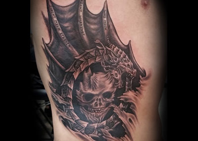 A black and white tattoo of a skull with horns