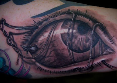 A tattoo of an eye with chains on it.