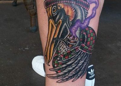 A man with a tattoo of a bird wearing a hat.