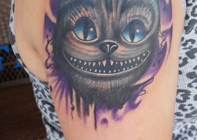 A woman with a cat face tattoo on her arm.