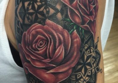 A tattoo of roses and lace on the arm.