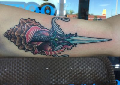 A tattoo of an octopus with a sword on it.