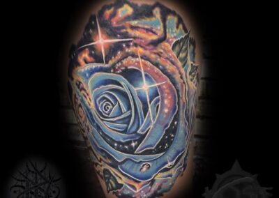 A tattoo of a rose with stars and other designs.