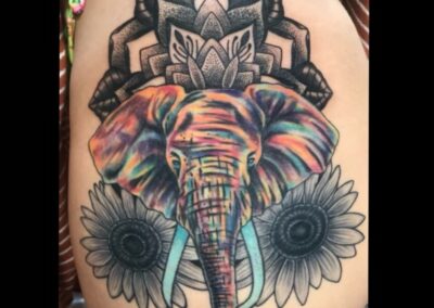 A woman with a colorful elephant tattoo on her back