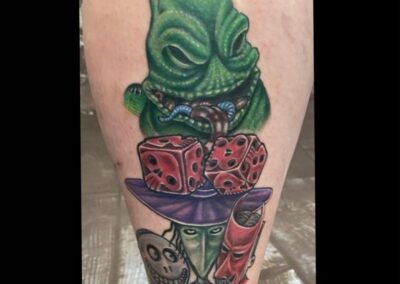 A tattoo of a green creature with various items on it.