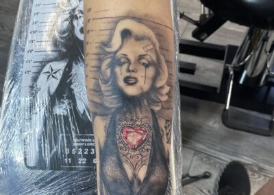 A tattoo of marilyn monroe is shown on the arm.