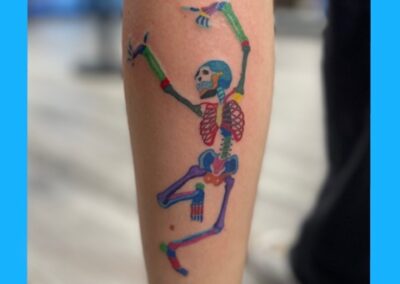 A tattoo of a skeleton with a blue background