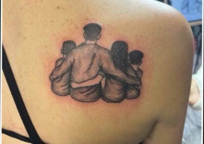 A tattoo of three people sitting on top of each other.