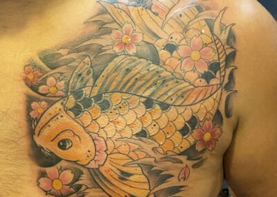 A man with a tattoo of a fish on his chest.