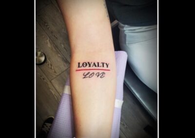 A person with loyalty tattoo on their arm.