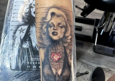 A tattoo of marilyn monroe is shown on the arm.